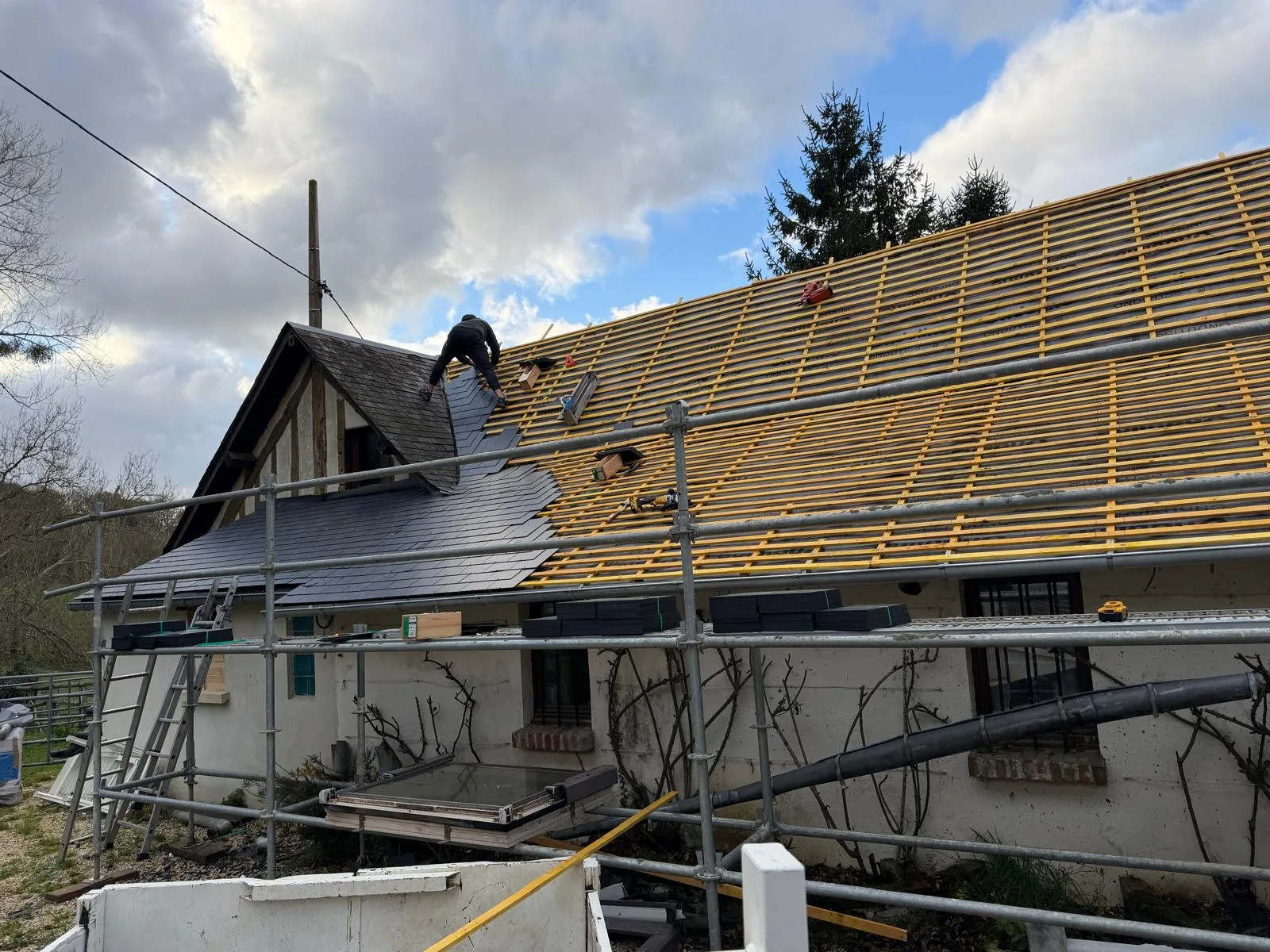 Pose d'ardoise en cours sur maison de campagne